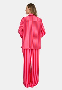 Rosa-rot gestreifter Pyjama-Set mit einem locker sitzenden Hemd und weit geschnittenen Hosen, aus glattem Stoff gefertigt mit einer entspannten Silhouette.