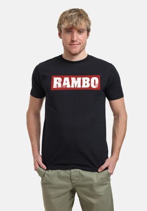 Sort bomulds t-shirt med et stort hvidt "RAMBO" grafisk motiv på en rød rektangulær baggrund, med rund hals og korte ærmer.