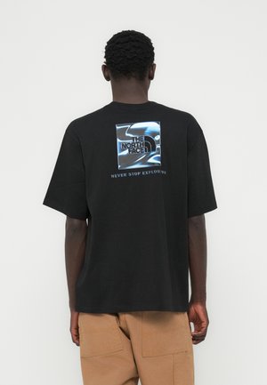 Μαύρο βαμβακερό μπλουζάκι με κοντά μανίκια, με γραφικό λογότυπο σε μπλε και λευκό στην πλάτη. Το κείμενο κάτω από το λογότυπο γράφει «NEVER STOP EXPLORING».