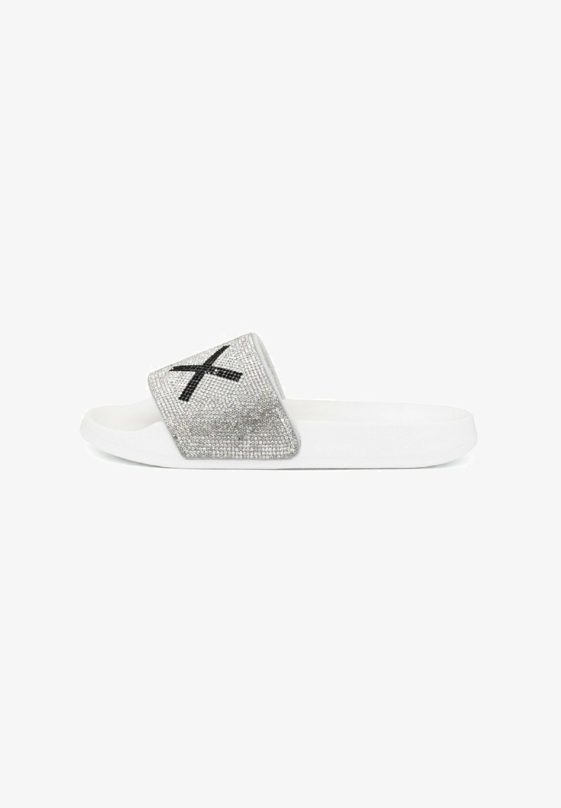 Slide sandal made of white rubber with a shimmering silver strap embellished with rhinestones and a black cross pattern.