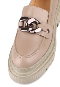 Beige Lederloafer mit einer strukturierten Plateausohle, die mit einer metallischen Kettenakzentuierung und gestickten Details im Obermaterial versehen ist.
