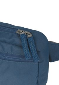 Borsa a tracolla blu in tessuto con doppie cerniere, materiale testurizzato e una tracolla regolabile. Dettaglio con cerniera situato sul lato.