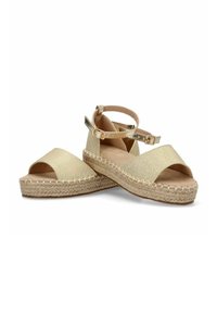 Sandalias espadrilles doradas con parte superior texturizada, puntas descubiertas y tira en el tobillo. La plantilla intermedia de yute trenzado añade altura y un detalle natural.