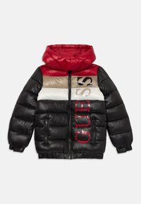 Detská prešívaná bunda s kapucňou, farebne kombinovaná v červenej, béžovej, bielej a čiernej farbe, s vertikálnym logom "GUESS" na prednej strane.