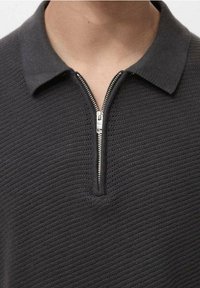 Polo gris foncé avec un motif en maille texturée, doté d'une fermeture à glissière à mi-hauteur et d'un col classique.