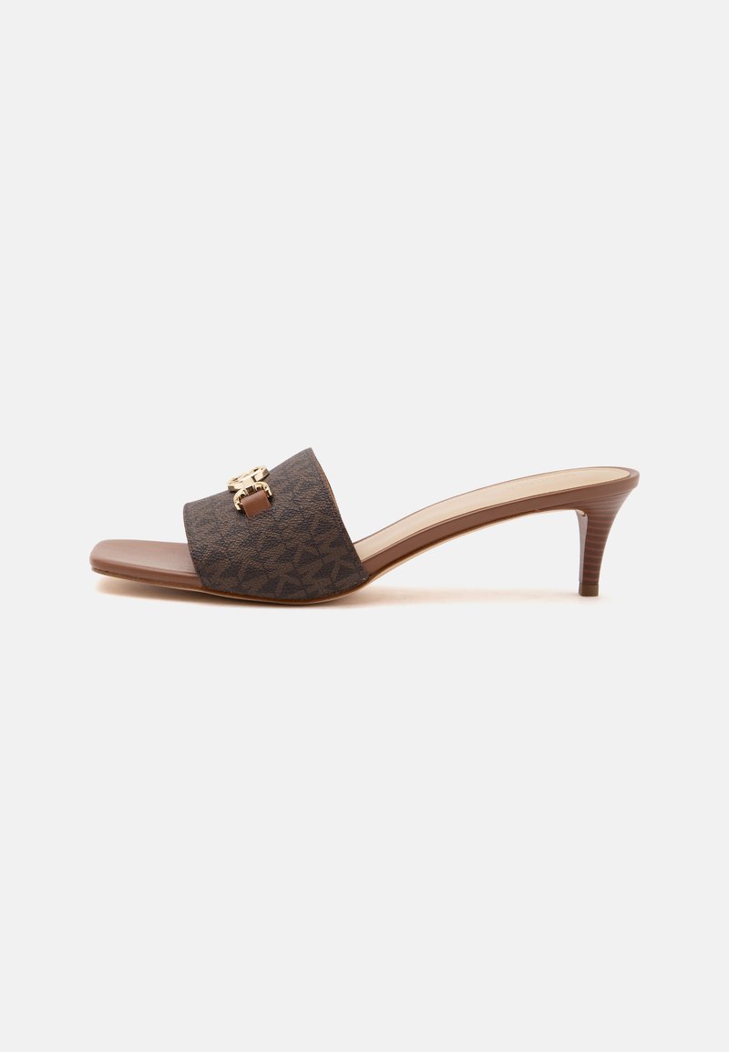 Mule marron à bout ouvert avec un petit talon empilé et une large bride présentant un motif subtil et une petite boucle dorée.