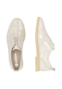 Chaussures à lacets en satin argenté clair avec une texture lisse, semelle en caoutchouc et un design à bout rond. Logo visible sur la semelle intérieure.