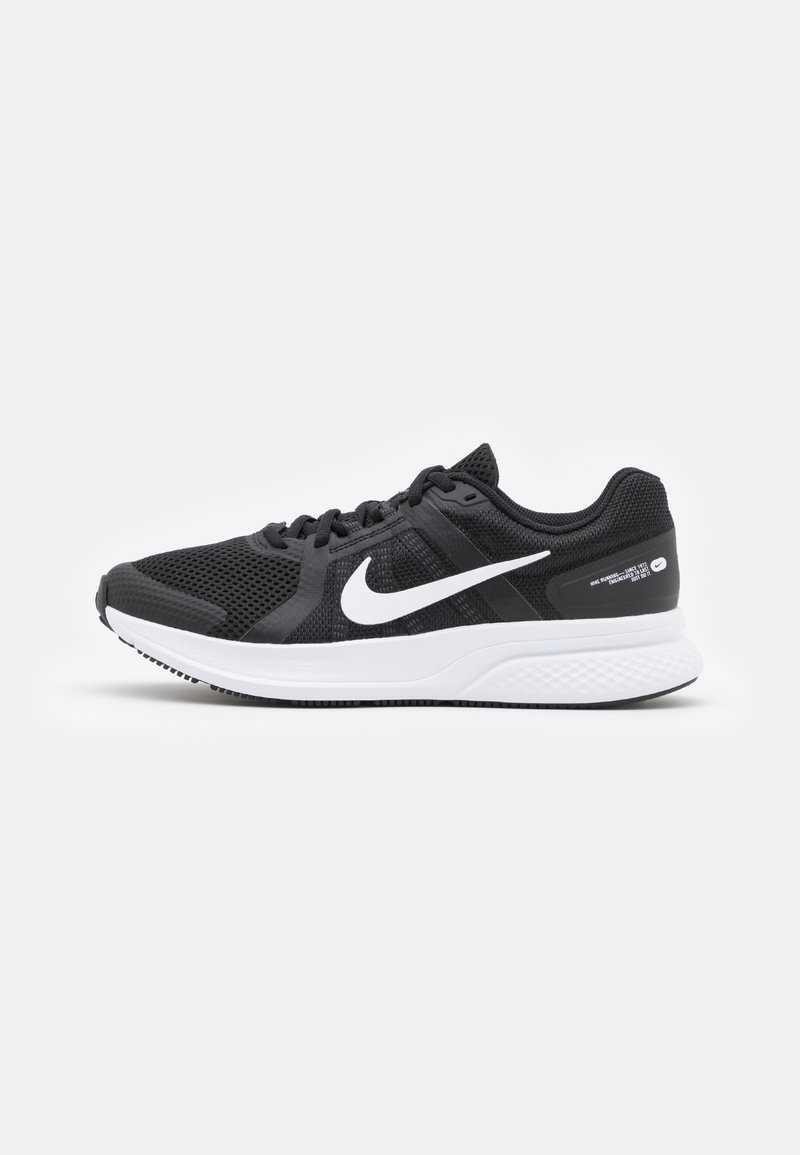 Baskets de sport noires avec tige en mesh, logo Nike blanc, design à lacets, semelle blanche rembourrée et semelle extérieure noire texturée.