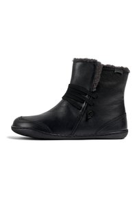 Bottines en cuir noir avec une doublure en fourrure grise douce, dotées de bandes élastiques pour la fermeture et d'une semelle flexible. Design simple et épuré.