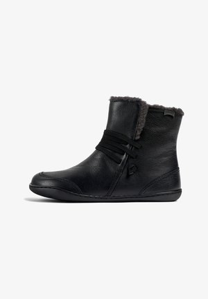 Schwarze Leder-Stiefeletten mit einem weichen grauen Fellfutter, ausgestattet mit elastischen Bändern zur Verschluss und einer flexiblen Sohle. Einfaches, elegantes Design.