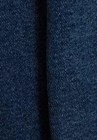 Tissu en denim bleu foncé avec un motif de toile texturé. La surface présente un tissage dense avec de subtils éclats de lumière à travers.