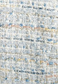 Geweven textiel met een lichtblauwe basis en gouden en pastelaccenten, dat een gestructureerd patroon van draden en door elkaar lopende tinten toont.