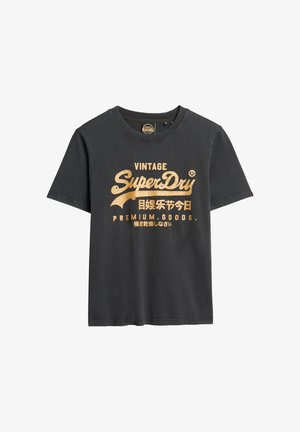 T-shirt noir à manches courtes avec texte doré « Vintage SuperDry Premium Goods » et caractères japonais imprimés sur le devant.