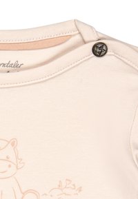 Helles rosa Baumwolloberteil mit Rundhalsausschnitt, einem metallischen Druckknopf mit Sternmotiv und einem niedlichen Tierdruck.