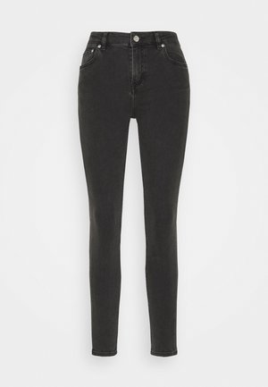 Jean skinny noir taille haute avec bouton à l'avant, fermeture éclair et cinq poches, sur fond blanc.