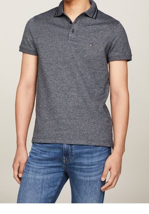 Mørkegrå kortærmet polo shirt lavet af tekstureret stof med en knaplukning og kontrasterende stribede detaljer på kraven.