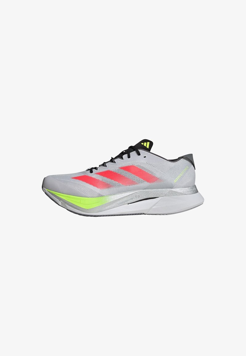 Chaussure de course légère en mesh gris avec des bandes rouges, des accents réfléchissants et une semelle verte ; présente un design épuré et aérodynamique.