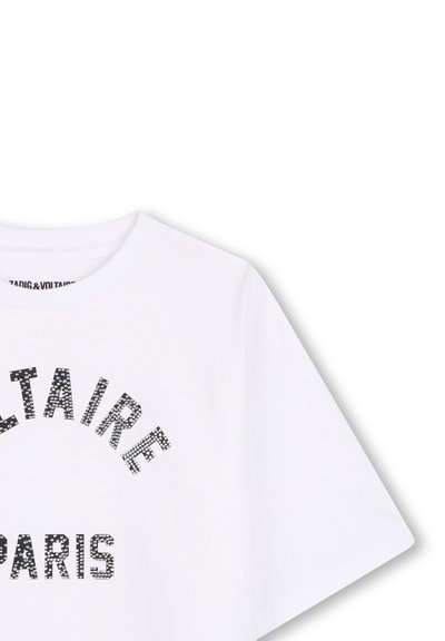 Λευκό πουκάμισο με κοντά μανίκια με μαύρα κουκκίδες γράμματα που σχηματίζουν το "CELTAIRE PARIS" στην περιοχή του στήθους.