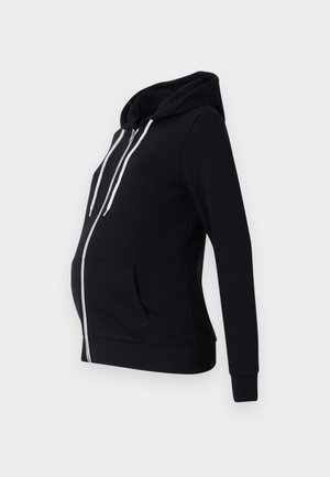 Felpa da maternità nera realizzata in un tessuto morbido, con zip frontale, due tasche laterali, maniche lunghe e cappuccio foderato con lacci bianchi.