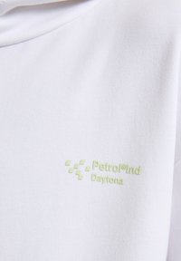 Felpa bianca in cotone con superficie testurizzata e un logo verde chiaro, "Petrol®Ind Daytona," sul lato sinistro del petto.
