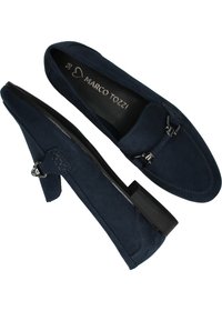 Navy blue suede slip-on shoes with a low block heel, featuring decorative hardware accents and stitched detailing on the sides.