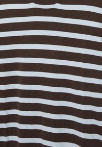 Rayures horizontales marron et blanches sur une surface en tissu avec une texture tricotée lisse.