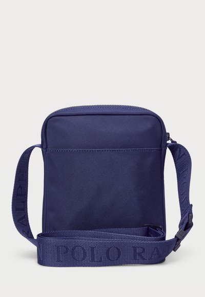 Geantă crossbody din material bleumarin, cu închidere cu fermoar, formă plată, curea ajustabilă cu logo embossat și textură netedă.