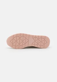 Shoe sole with a textured surface, featuring a pink rubber material. Diamond and linear patterns provide traction. Lightweight design.