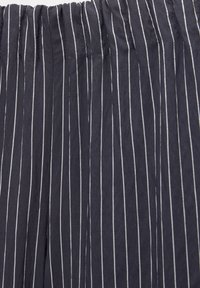 Granatowa tkanina w białe pionowe paski, z plisowaną teksturą. Materiał wydaje się lekki i lekko pomarszczony.