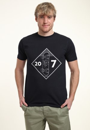 Černé bavlněné tričko s diamantovým grafickým designem obsahujícím čísla "20" a "7" a design skateboardu v bílém obrysu. Krátké rukávy.