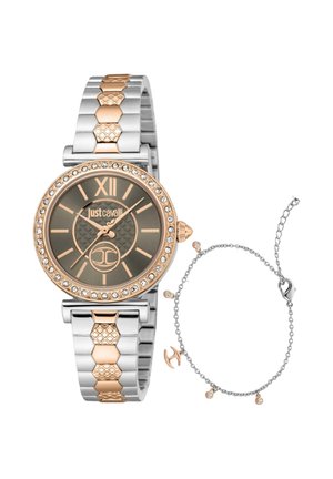 Ronde tweekleurige gouden en zilveren polshorloge met kristallen lunette en bijpassende zilveren kettink armband met kleine gouden bedels.