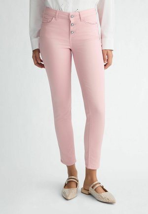 Light pink skinny jeans with a high waist, featuring a five-button closure and front pockets, made from a smooth, stretchy fabric.