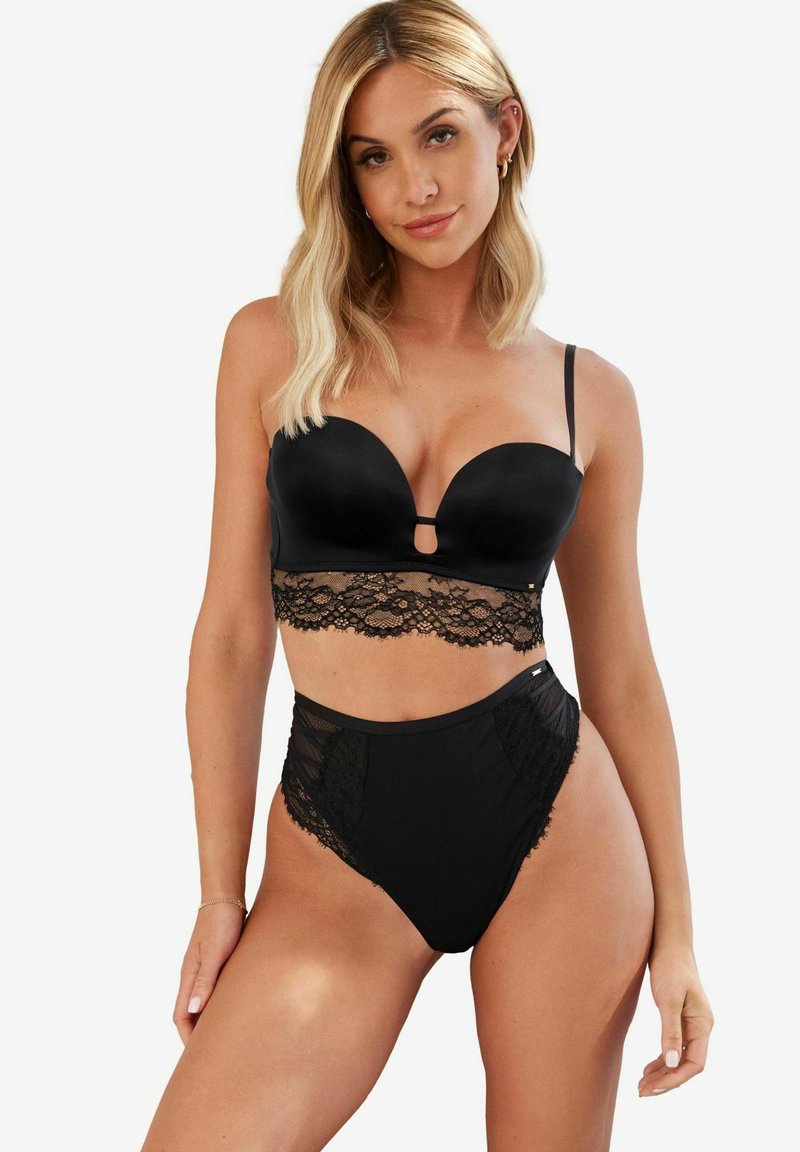 Musthave musta aluspesu komplekt, mis sisaldab siledat, polsterdatud rinnahoidjat pitsist äärega ja sobivaid kõrge taljega aluspükse pitsi aktsentidega.