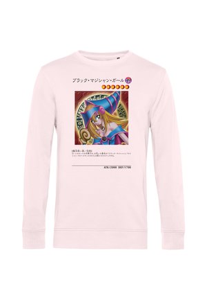 Lyserød langærmet skjorte med en farverig anime-stil karakter iført en lilla heks hat og blå outfit foran.