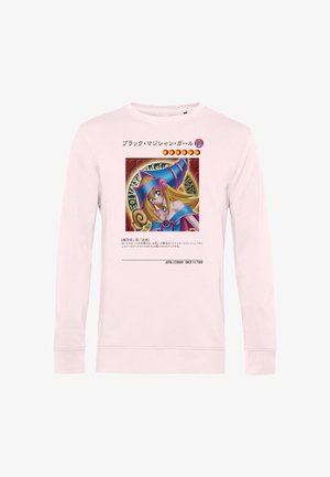Lyserød langærmet skjorte med en farverig anime-stil karakter iført en lilla heks hat og blå outfit foran.
