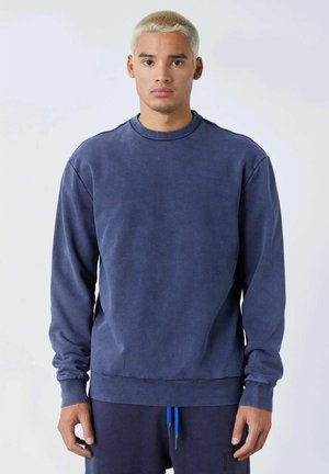 Sudadera azul marino con cuello redondo, mangas largas y puños y dobladillo acanalados. Confeccionada en un tejido suave con una textura lisa.