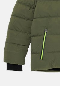 Giacca puffer verde oliva con cuciture orizzontali, caratterizzata da una tasca con zip con un accento verde neon e polsini a coste neri.