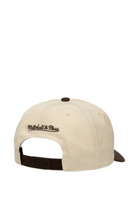 Cream baseball cap featuring brown accents, adjustable snapback closure, and embroidered "Mitchell & Ness" logo on the back.