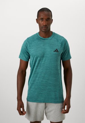 Turquoise athletic t-shirt made of textured fabric, featuring a round neckline and short raglan sleeves. Black logo on chest.