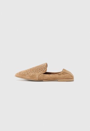 Mocassin plat en daim couleur fauve, à bout pointu et orné de petits clous métalliques sur le dessus, présenté de profil sur un fond uni.