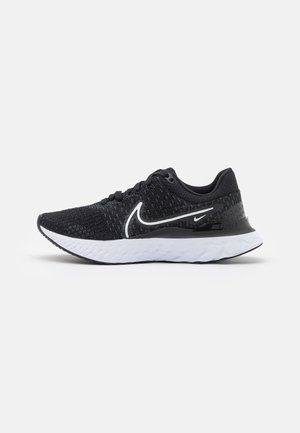 Black athletic shoes with a textured upper, white Swoosh logo, and a cushioned white sole. Features include laces and a padded collar.