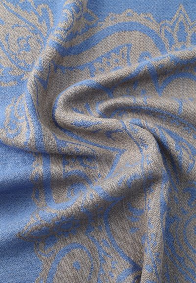 Tissu bleu et beige avec des motifs floraux et cachemire complexes, présenté dans une texture douce et pliée.