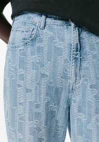 Lichtblauwe denim jeans met een reliëfpatroon van visgraat en geometrische vormen, met een klassieke vijf-vakkenontwerp.