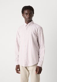 Camicia bianca a righe verticali rosse, con colletto e maniche lunghe, realizzata in un tessuto liscio con una leggera lucentezza.
