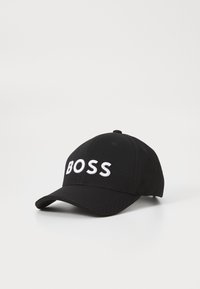 Fekete, anyagból készült sapka, ívelt karimával és fehér hímzett "BOSS" logóval az elején. Egyszerű, letisztult dizájn.
