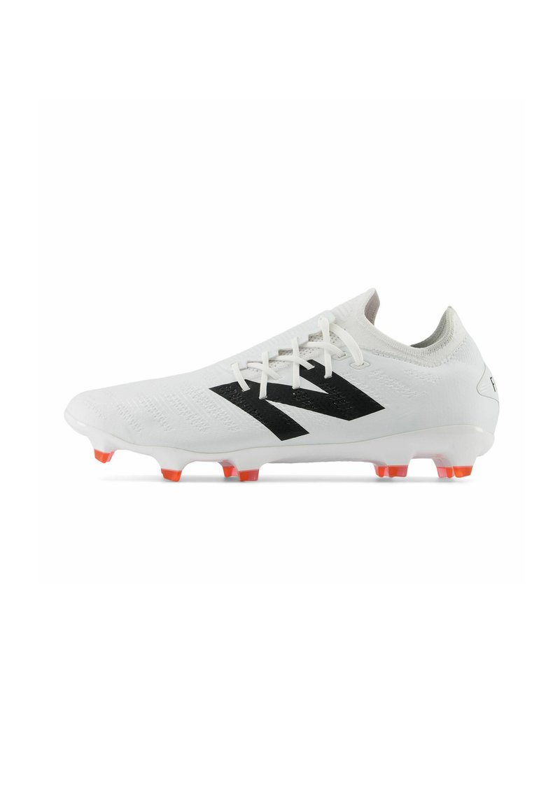Botte de football blanche avec un logo noir, empeigne texturée et un accent orange sur les semelles. Conçu pour l'adhérence sur les surfaces en herbe.