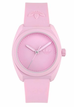 Montre en silicone rose avec un cadran rond, aiguilles des heures et des minutes de couleur rose clair contrastante, et un logo de la marque gravé sur le cadran.
