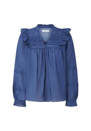 Tumedat sinine pluus, millel on volangiga äärised kaela ja õlgade juures. Omab V-kujulist kaelust, pikkade varrukate ja kogutud tekstuuriga.