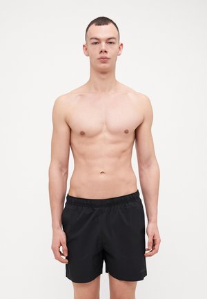 Bañador negro con cintura elástica, hecho de un tejido suave y ligero. Un diseño sencillo sin patrones ni acentos visibles.