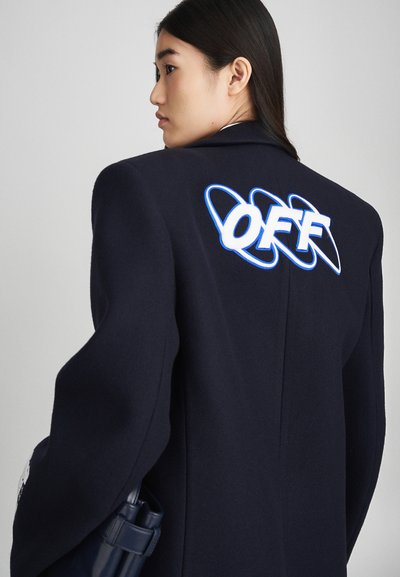 Cappotto in misto lana blu navy con un grande logo bianco e blu "OFF" sulla schiena, spalle strutturate e una texture morbida.